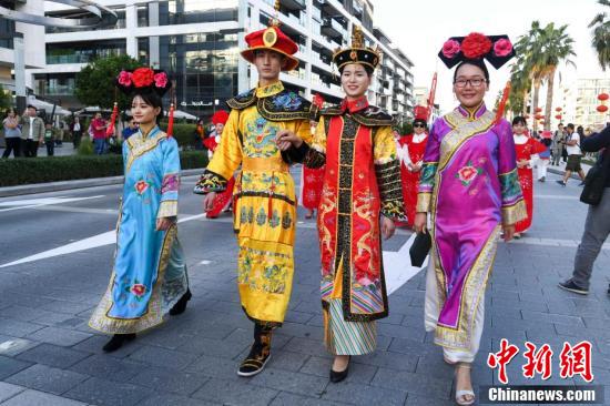 巡游人员身着中国古代服饰行走在街头.