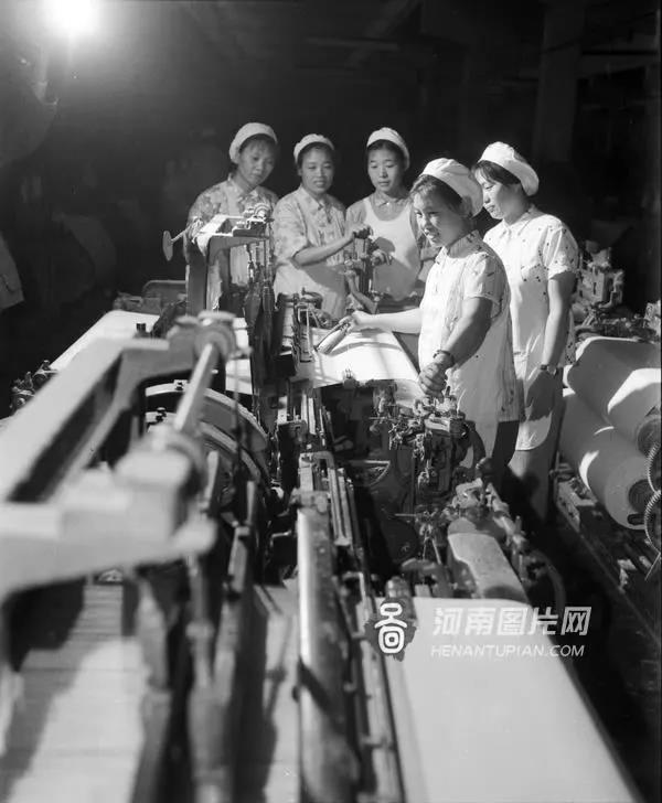1954年,郑州国棉一厂新建成时,女工在织布间试机.