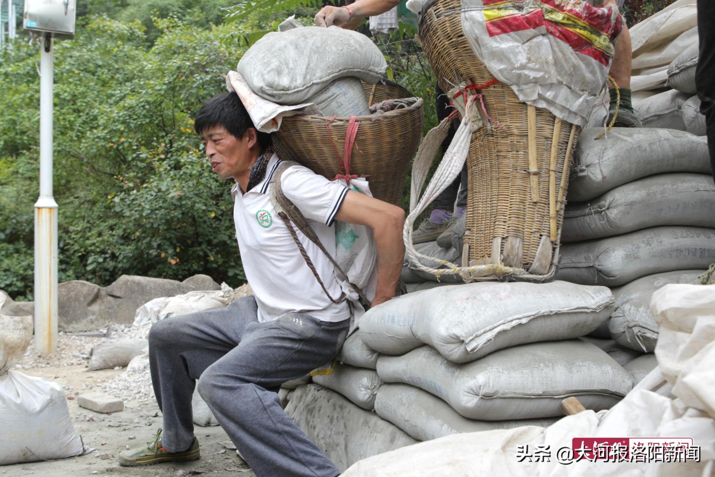 河南洛阳的老君山中 一位51岁的父亲靠着每日挑水泥供出2位大学生