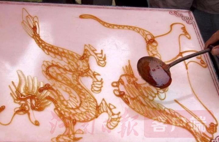 "10月13日,一名穿着时尚的女孩路过淮滨县淮河公园一个转糖摊时,停下